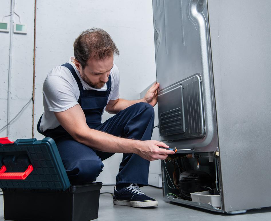 Ridgeway technician working on the back of a fridge